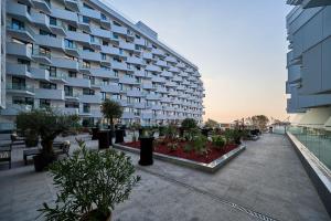 um grande edifício de apartamentos com um pátio com plantas em Alezzi Infinity Aparthotel & Spa em Mamaia Nord – Năvodari