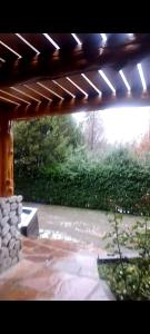 un patio con un banco de piedra bajo una pérgola en Tu lugar soñado en Villa La Angostura