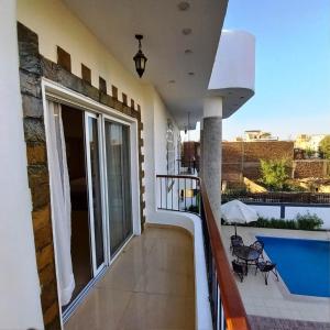 a balcony of a house with a swimming pool at Ali Luxury Villa in Luxor