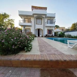 a house with a swimming pool in front of it at Ali Luxury Villa in Luxor