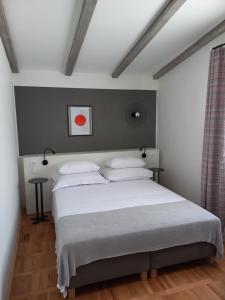- une chambre avec un grand lit blanc et des oreillers blancs dans l'établissement Unique residence with garden and sea view, à Split