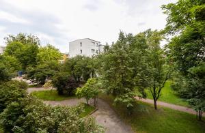 a park with trees and a building in the background at Ochota Standard Apartment in Warsaw