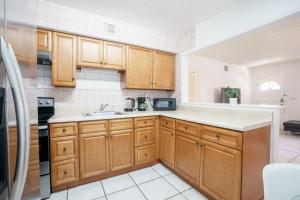 a kitchen with wooden cabinets and a sink at Modern 2 Bedroom in the Heart of Wynwood Art District in Miami