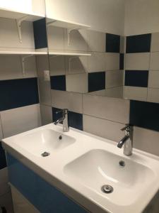 a bathroom sink with two faucets and a mirror at L’ABSINTHE in Bannans +2 photos