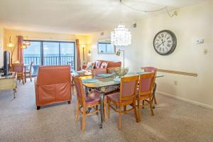 a dining room with a table and chairs and a clock at The Colony at Virginia Beach by TripForth in Virginia Beach