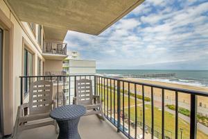 balcón con mesa, sillas y vistas al océano en The Colony at Virginia Beach by TripForth en Virginia Beach