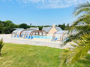 una piscina con sillas azules junto a un edificio en Maison résidence Odalys à Morgat en bretagne sur la presqu'île de crozon ,piscine chauffée, située à 800 m de la mer, en Crozon