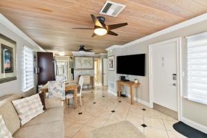 a living room with a ceiling fan and a dining room at 113 Surf Song Resort in St Pete Beach