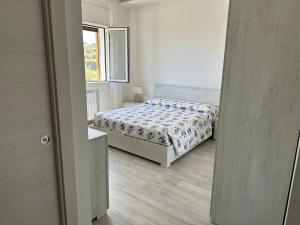 een kleine slaapkamer met een bed en een raam bij Camere private vista Faraglioni - Aci Trezza in Aci Castello