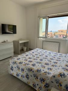 een slaapkamer met een bed, een raam en een televisie bij Camere private vista Faraglioni - Aci Trezza in Aci Castello