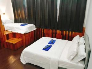 喬治市的住宿－sungai ujong home stay，一间卧室配有两张带蓝色餐巾的床。