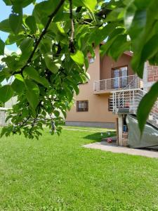 a house with a green yard with a building at Vila Sultan Sarajevo in Sarajevo