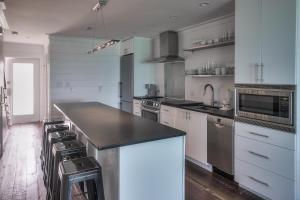 a kitchen with white cabinets and a black counter top at The Good Life in Inlet Beach