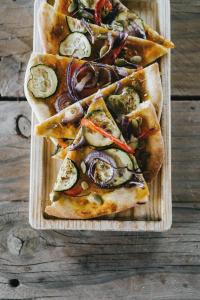 tres porciones de pizza en una bandeja de madera en Humus Farm, en Águas de Moura