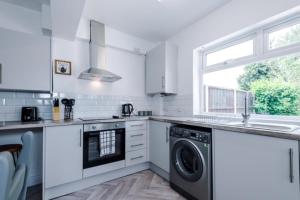 a kitchen with a washing machine and a sink at Beautiful 3 bedroom property , Sleeps 6 in Crewe