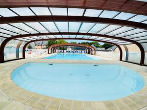 una gran piscina con techo abovedado en Maison résidence Odalys à Morgat en bretagne sur la presqu'île de crozon ,piscine chauffée, située à 800 m de la mer, en Crozon