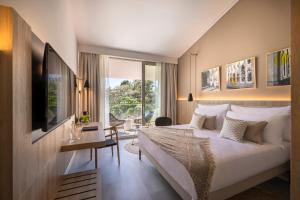 Schlafzimmer mit einem Bett, einem Schreibtisch und einem Fenster in der Unterkunft Valamar Tirena Hotel in Dubrovnik