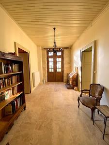 sala de estar con estante de libros y silla en Chambres d'hôtes de charme avec piscine - Le Clos Boissiere, en Valence-sur-Baïse