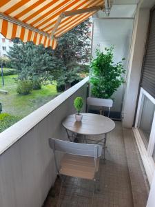 a patio with a table and chairs on a balcony at Le mûrier - 2 chambres chez l'habitant in Rhut
