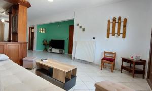un soggiorno con letto, tavolo e TV di Piccolo Alloggio a Tsoukalades