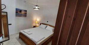 una piccola camera da letto con un letto con lenzuola bianche di Piccolo Alloggio a Tsoukalades