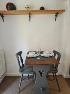 a dining room table with two chairs and a table with glasses at Cosy Cottage for work or leisure, RD&E 20min walk, easy access to city centre in Exeter