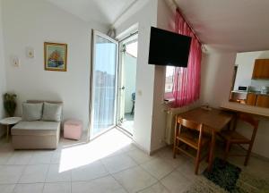 uma sala de estar com um sofá, uma mesa e uma televisão em Studio apartman Olivera em Rovinj