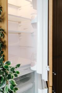 an open refrigerator door with a plant in it at Butique Apartman in Balatonlelle