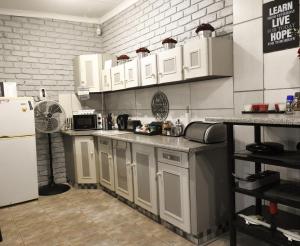 a kitchen with white cabinets and a refrigerator at Spruitjie-roer-my-nie in Potchefstroom