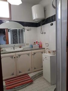 y baño con lavabo y espejo. en Casa vacanze Antonella, en Oristano