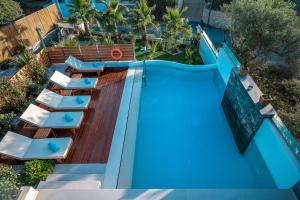- une vue sur la piscine et ses chaises longues dans l'établissement Aida Luxury Villas, à Analipsi