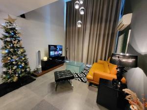 a living room with a christmas tree and a couch at Empire Damansara Designer Soho Karaoke & Netflix in Petaling Jaya