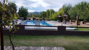 a swimming pool in a yard next to a yard at Complejo de Cabañas Tierra Nuestra in Mina Clavero