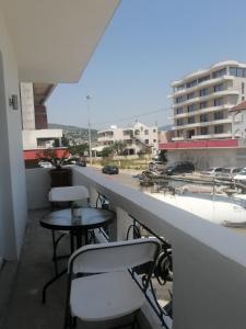 a balcony with chairs and tables and a view of a street at Dizara Apartman's in Ulcinj