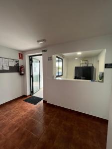an empty living room with a room with a television at ALBERGUE CASTELOS VILALBA in Villalba