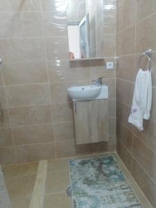y baño con lavabo y espejo. en Dizara Apartman's en Ulcinj
