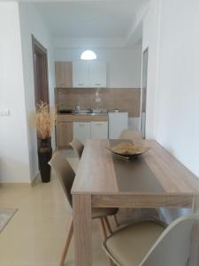 een eetkamer met een houten tafel en stoelen bij Dizara Apartman's in Ulcinj