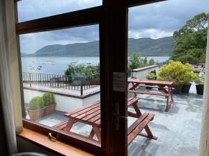 a view from a window of a picnic table and a lake at The Royal Hotel in Ullapool