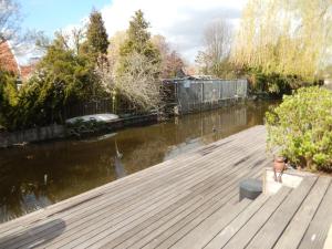 a dog sitting on a dock next to a river at Apartment Amsterdam New West - Free parking in Amsterdam
