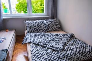 a bed with pillows on it in a room with a window at Studio Szczęśliwa 36 przy SkyTower! in Wrocław