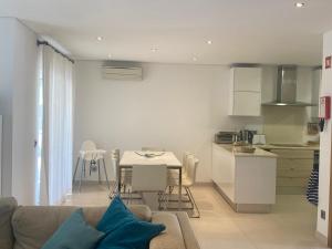 een woonkamer en keuken met een bank en een tafel bij Casa de praia in Manta Rota