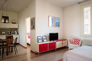 a bedroom with a bed and a desk with a television at Accomodo MIB13 Bivano Navigli in Milan
