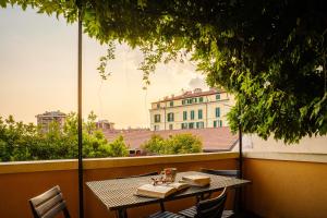 a table on a balcony with a view of a building at Accomodo MIB13 Bivano Navigli in Milan