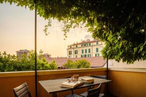 a table on a balcony with a view of a building at Accomodo Milano - MIB13 Bivano Navigli in Milan