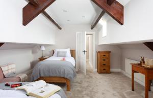 a attic bedroom with two beds and a desk at The Old School House in Bainbridge