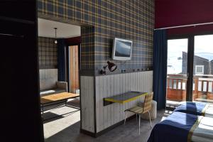 a room with a bed and a tv on a wall at Langley Hôtel Tango in Val Thorens