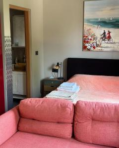 ein Schlafzimmer mit einem rosa Bett und einem rosa Sofa in der Unterkunft Kuća Aurora in Rovinj