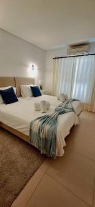 a large bed in a room with a large window at Casa de praia in Manta Rota
