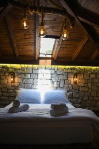 um quarto com uma cama numa parede de pedra em Anhel Hotel em Berati