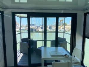 a room with a table and chairs and a view of the water at Houseboat Cádiz El Puerto - Casa Flotante in El Puerto de Santa María +33 photos